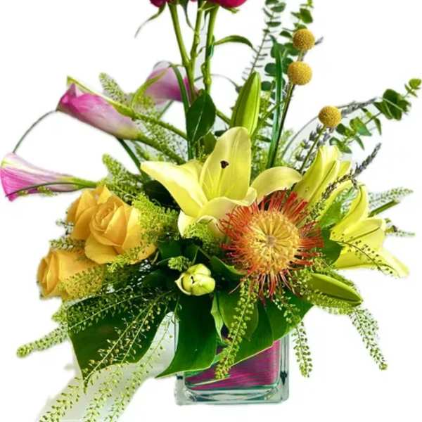 Mixed bouquet in a clear glass vase with lilies, roses, and pink blooms