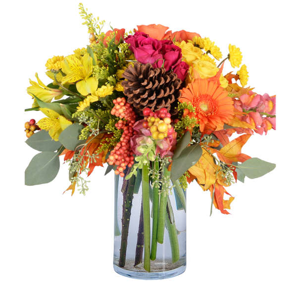 Autumn bouquet of mixed flowers in a clear glass vase with a pinecone centerpiece
