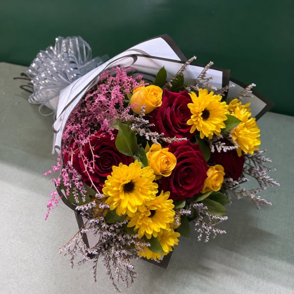 Bouquet of red and yellow roses with yellow daisies and pink filler flowers