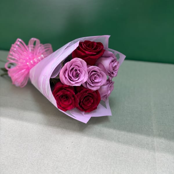 Bouquet of red and lavender roses wrapped in pink paper