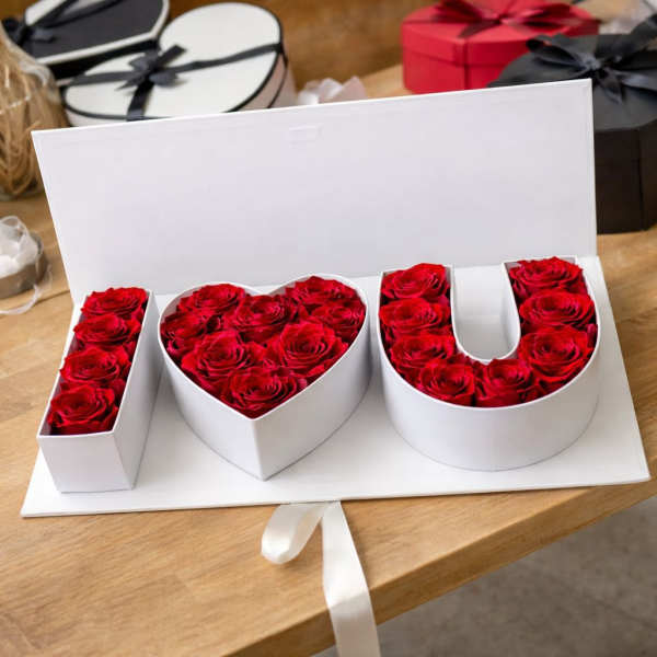 Red roses arranged in a white box spelling I heart U
