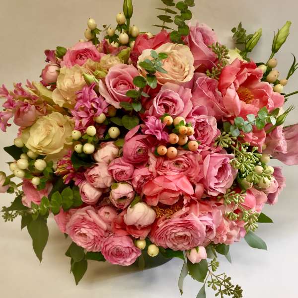 Round bouquet of pink and cream flowers with berries and greenery