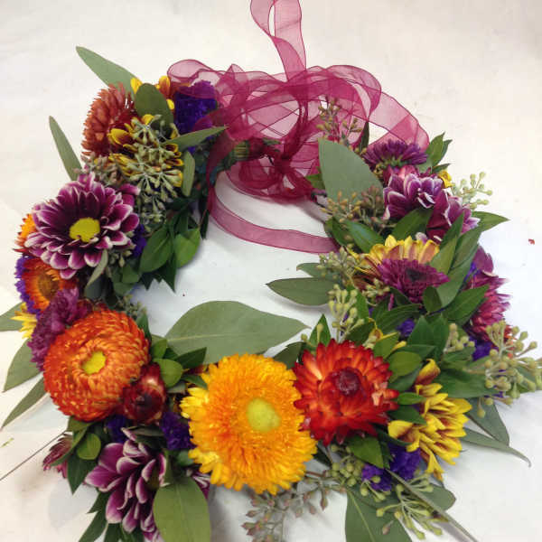 Colorful flower wreath with a magenta ribbon bow