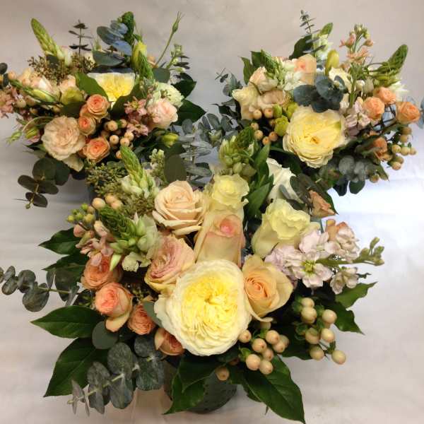 Three pastel floral bouquets with roses and eucalyptus on a white background