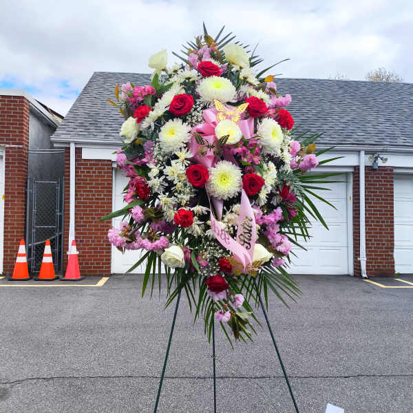 Large standing floral spray with red and white flowers on an easel