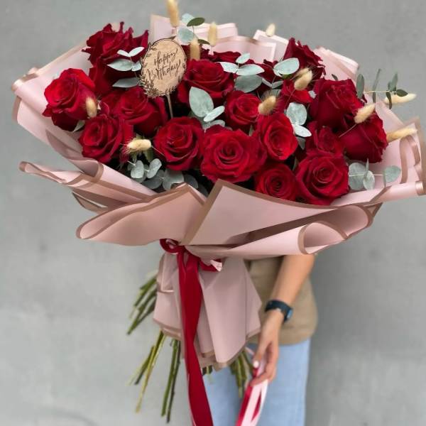 Bouquet of red roses with pale eucalyptus and pink wrapping