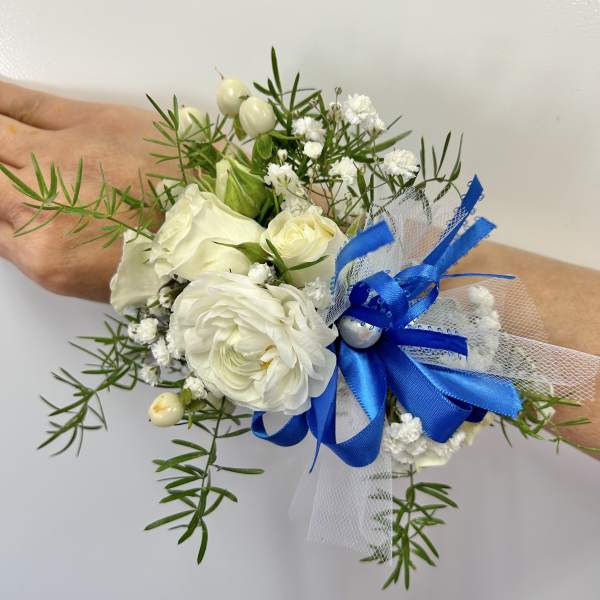 White floral wrist corsage with blue ribbon and tulle