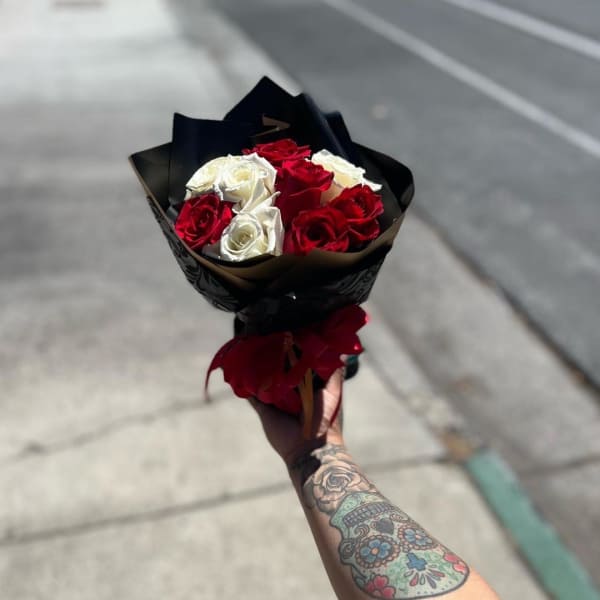 Bouquet of red and white roses wrapped in black paper