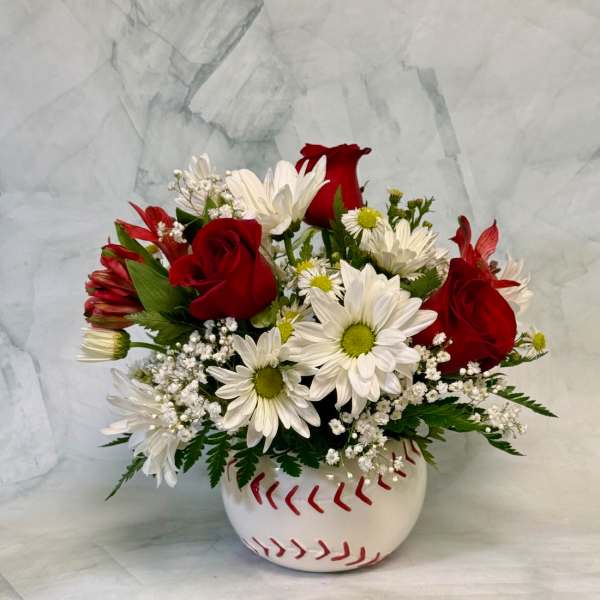 Red roses and white daisies in a baseball-shaped vase