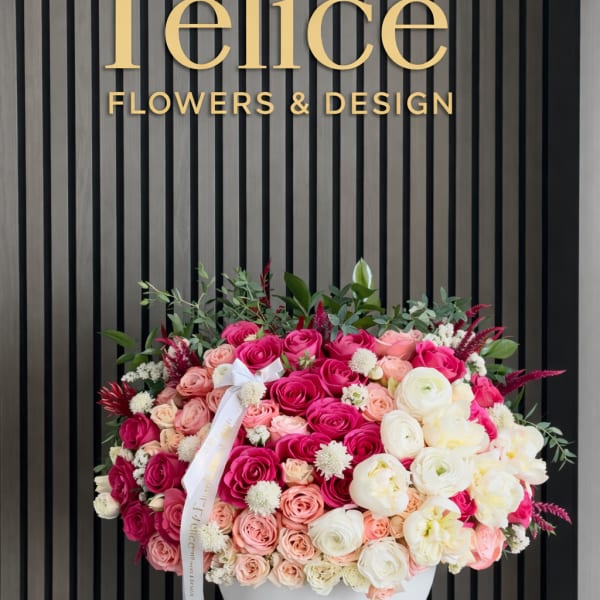 Large pink and white rose arrangement in a white vase