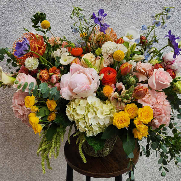Large mixed bouquet in a vase with pink, yellow, orange, purple, and white flowers