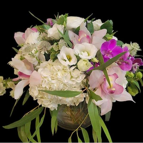 Pink and white floral arrangement in a glass vase