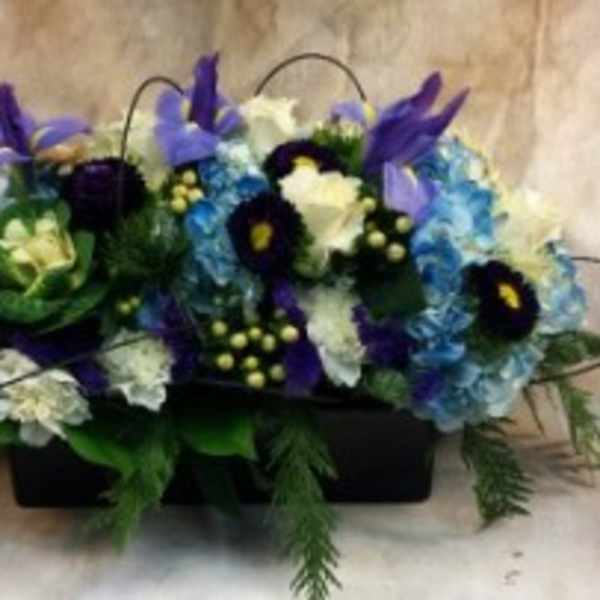 Mixed blue, purple, and white floral arrangement in a black container
