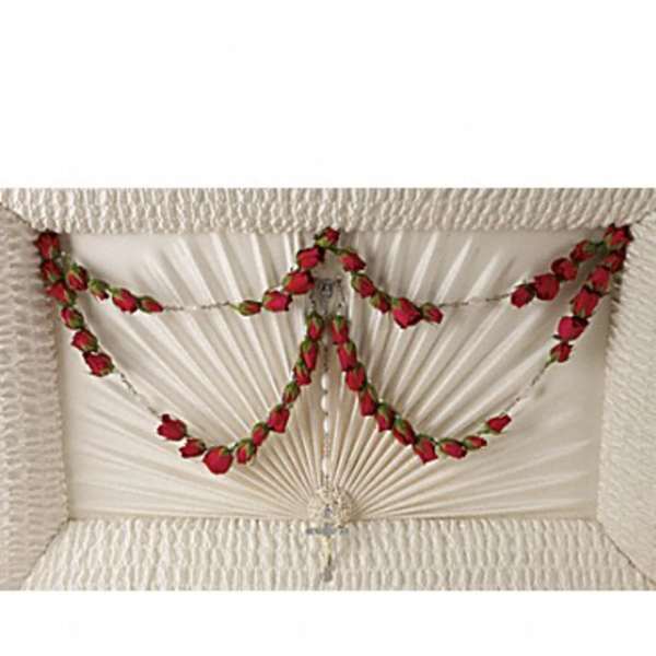 White casket with red rose garland draped across the lid