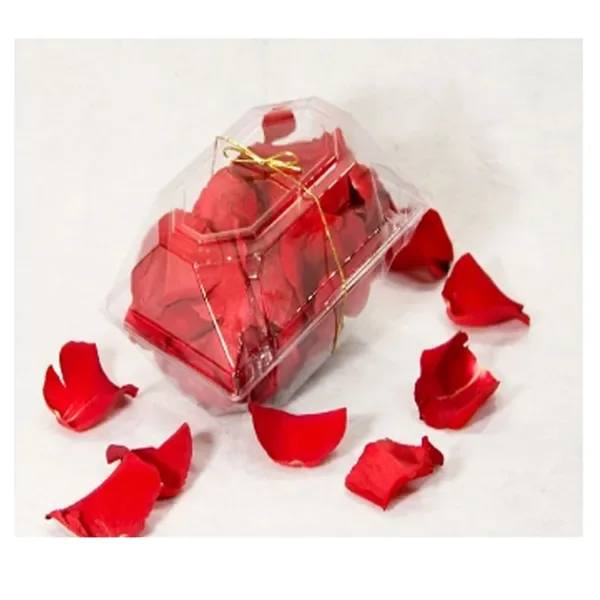 Clear gift box filled with red rose petals and tied with a gold ribbon