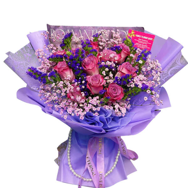 Pink roses with purple filler flowers wrapped in lavender paper