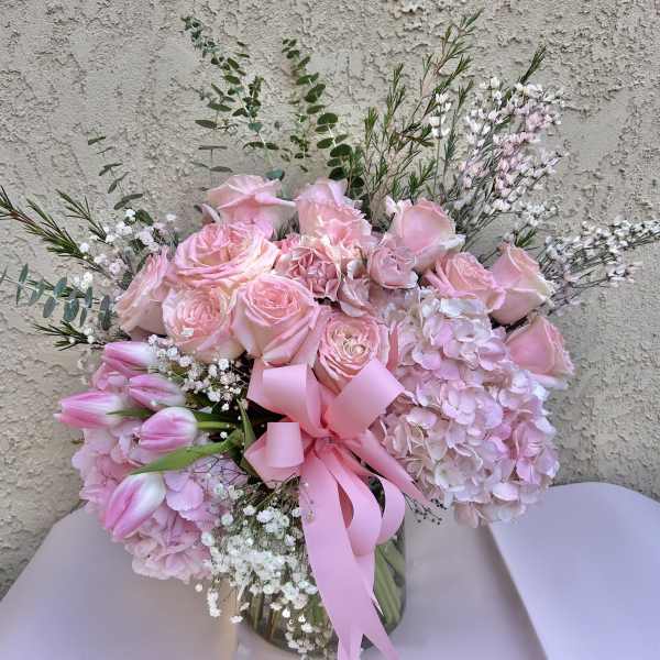 Pink rose bouquet with hydrangeas and tulips in a glass vase