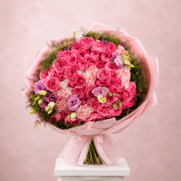 Pink bouquet of roses and lisianthus wrapped in pale pink paper