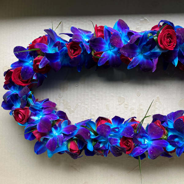Oval floral wreath of blue-purple orchids and red roses