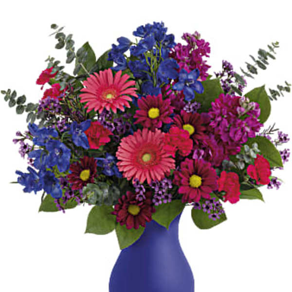 Colorful mixed bouquet in a blue vase with pink and purple flowers