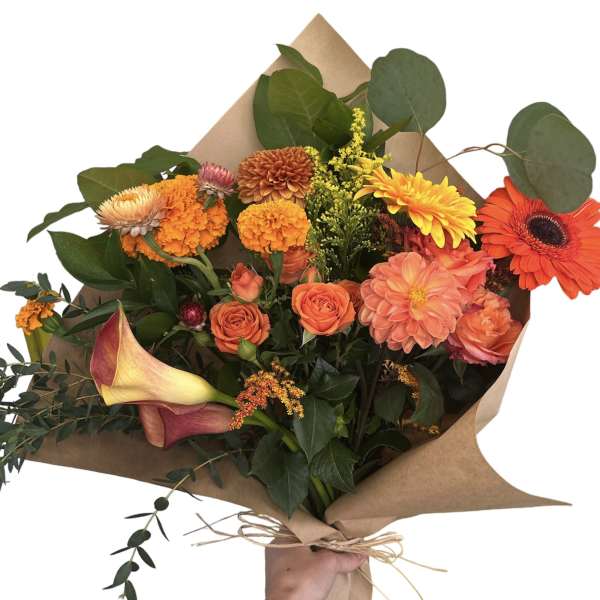 Hand-tied bouquet with orange and yellow flowers wrapped in brown paper