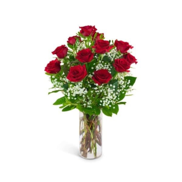 Red roses arranged in a clear glass vase with white filler flowers