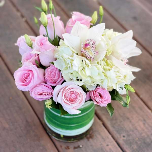 Pink roses and white hydrangeas in a green striped vase