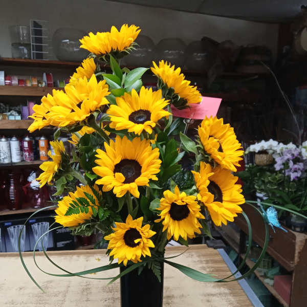 Yellow sunflower arrangement in a tall black vase
