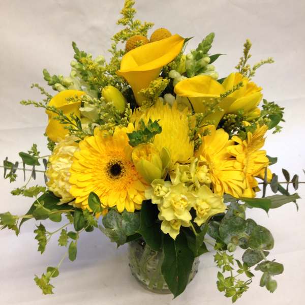 Yellow floral arrangement in a clear glass vase