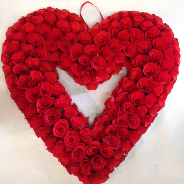 Heart-shaped arrangement of red roses on a white background