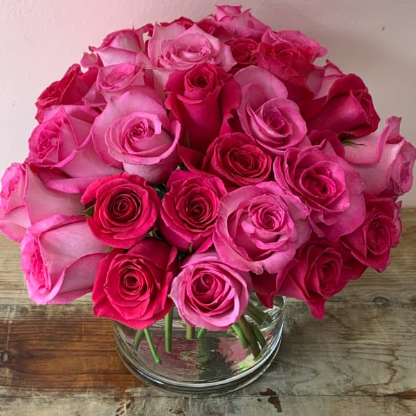 Pink and hot pink roses arranged in a clear glass vase