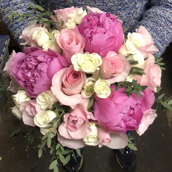 Bouquet of pink peonies, roses, and white mini roses with greenery