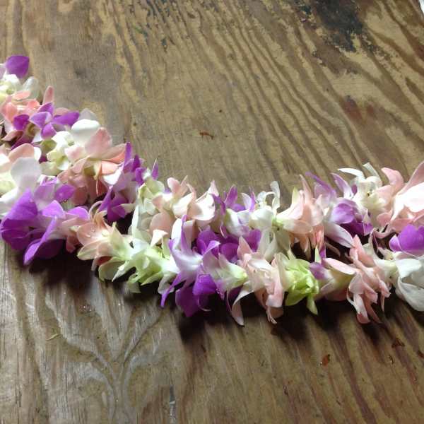 A pastel flower lei made of purple, pink, and white blossoms.