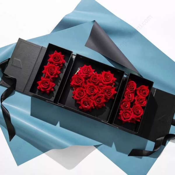 Black gift box with red roses arranged in three compartments