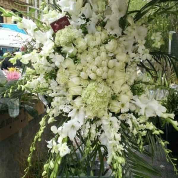 Large white floral standing arrangement with cascading blooms