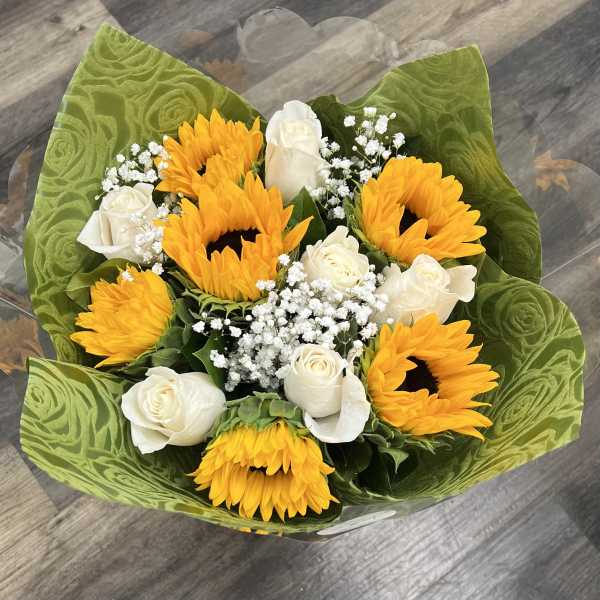 Bouquet of yellow sunflowers and white roses wrapped in green paper