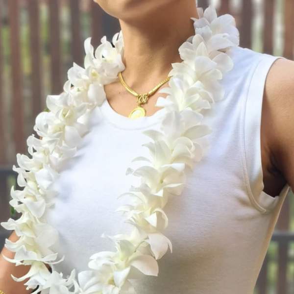 White orchid lei draped around a person wearing a sleeveless top