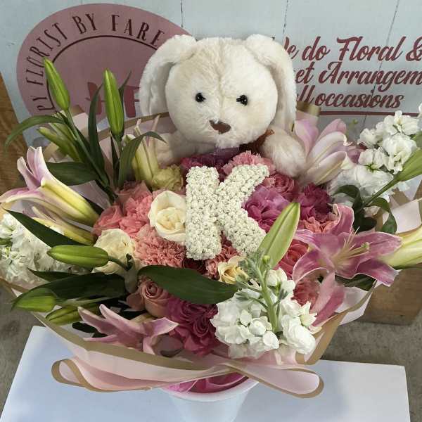 Pink and white bouquet with lilies, roses, and a teddy bear