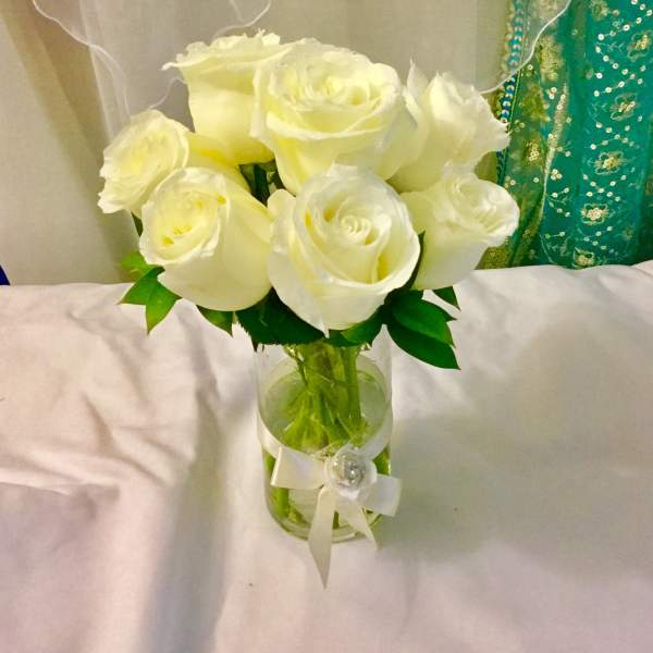 Bouquet of white roses in a glass vase with a ribbon