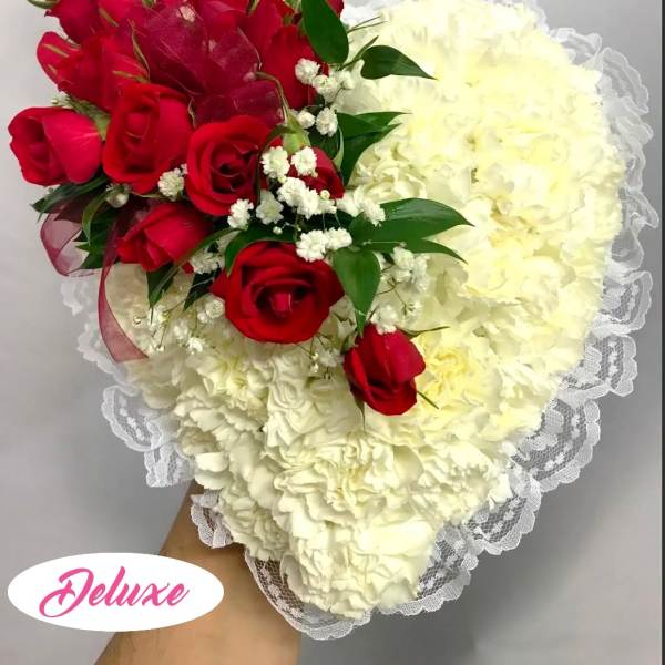 Heart-shaped bouquet of red roses and white carnations with lace trim
