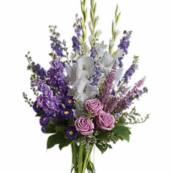 Purple and pink mixed flower arrangement in a clear glass vase