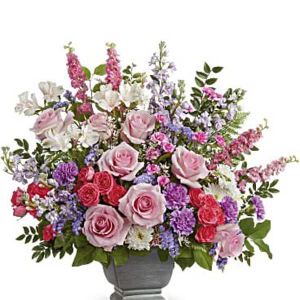 Mixed pink and purple floral arrangement in a gray urn vase