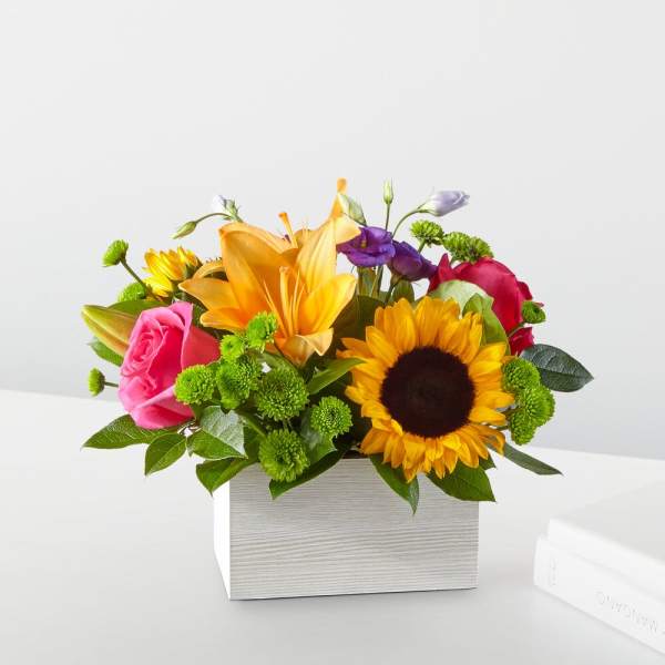Mixed bouquet with sunflowers, roses, and lilies in a white box