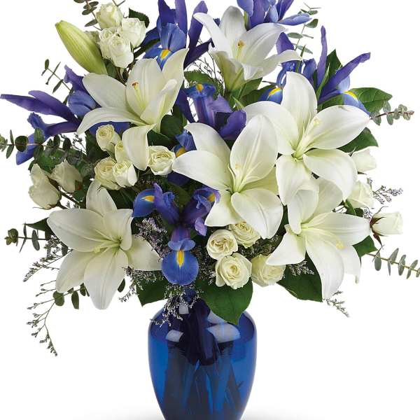 White lilies and blue irises in a cobalt vase