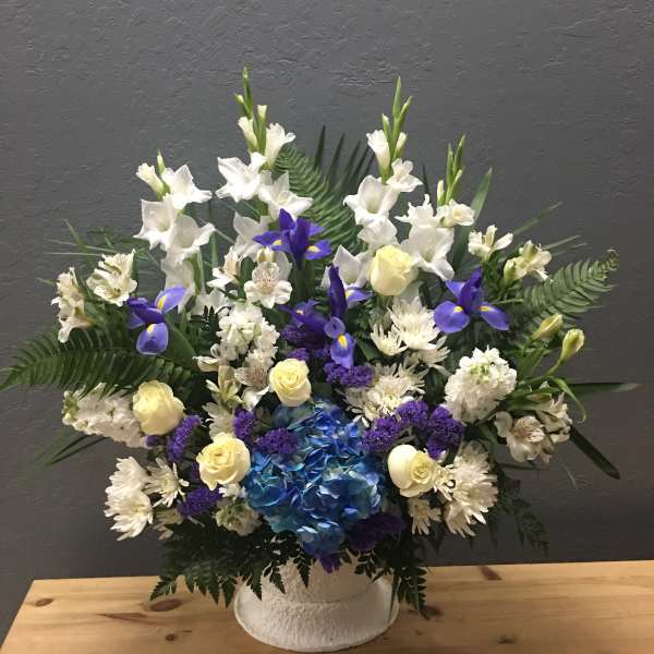White and blue floral arrangement in a white vase