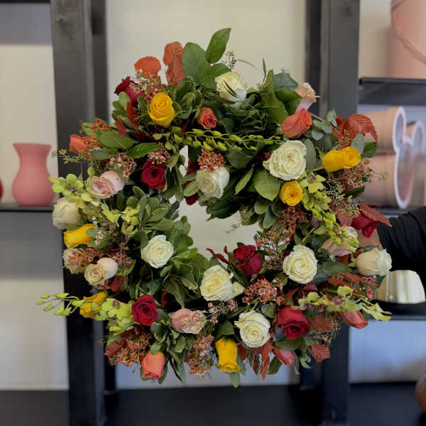 Circular wreath of multicolored roses and greenery