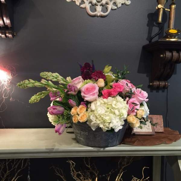 Mixed bouquet in a dark metal container with pink, white, and purple blooms