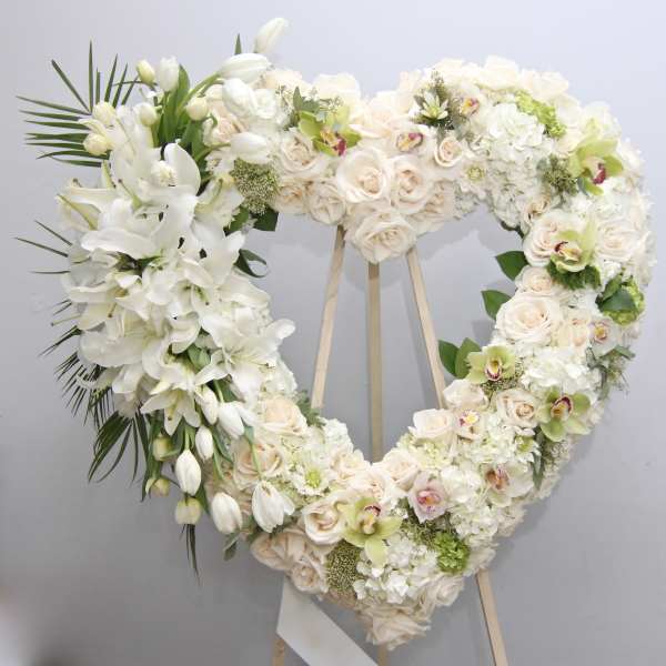 Heart-shaped white floral wreath on an easel