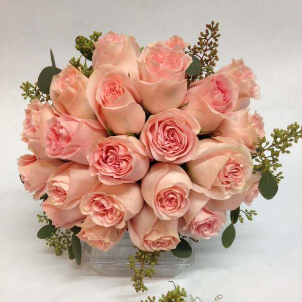 Bouquet of pale pink roses with greenery in a clear vase