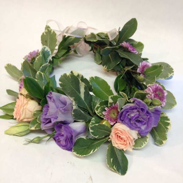Floral wreath with purple and peach blooms on variegated greenery